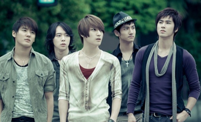 The five members of TVXQ standing together outdoors during their five-member era.