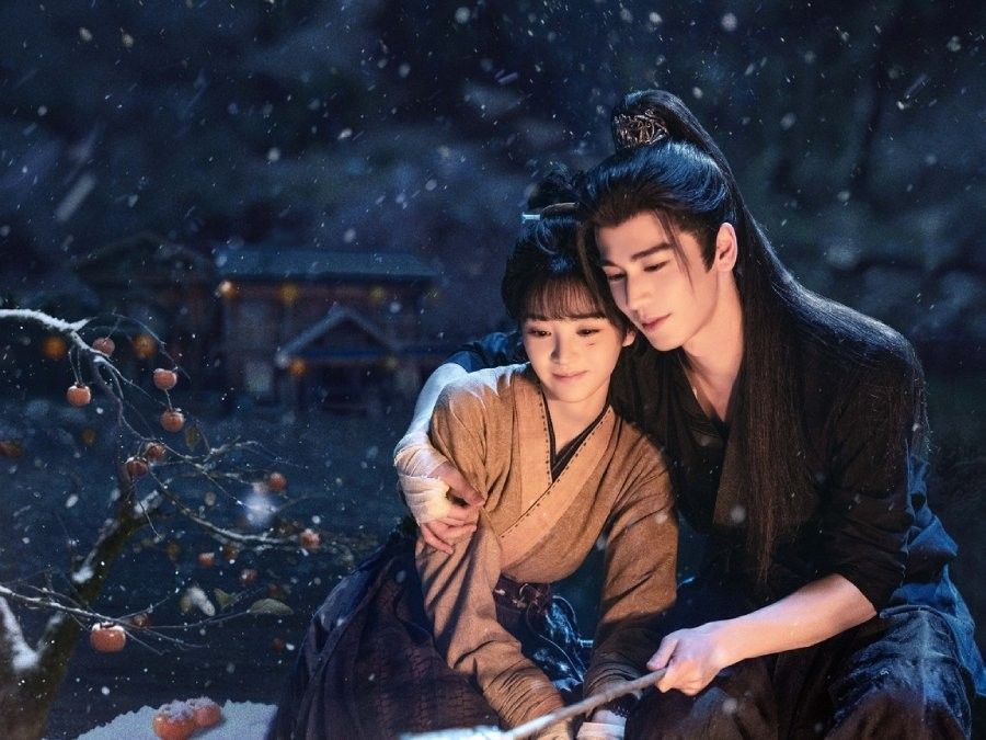 Tian Xiwei as Fan Changyu and Zhang Linghe as Xie Zheng sitting together in a snowy nighttime scene from Pursuit of Jade.