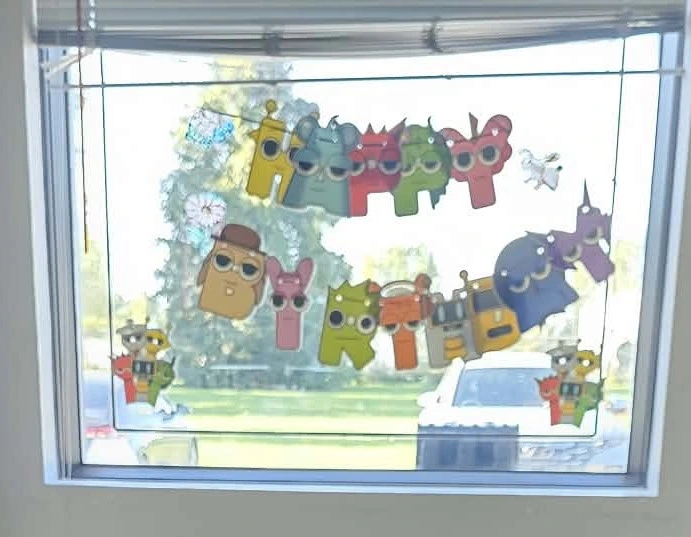 Colourful Numberblocks birthday decorations spelling Happy Birthday across a bright window.