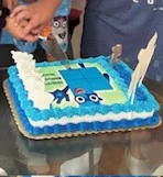 Blue Numberblock Five birthday cake on a glass table.