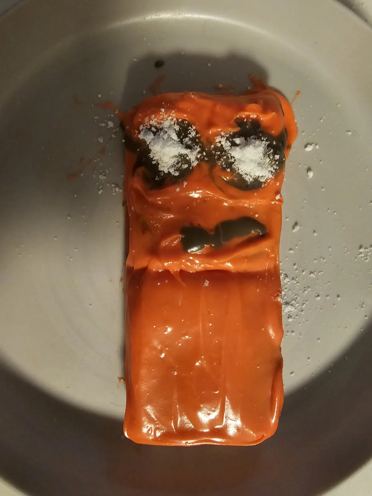 Homemade orange Numberblock Two cake with two chocolate-and-coconut eyes and a chocolate mouth.